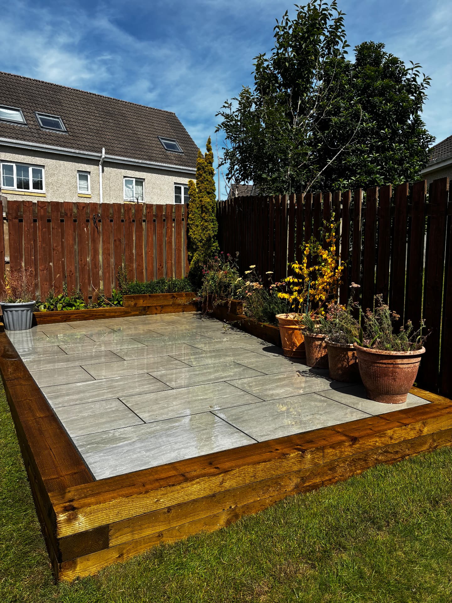 Kandla grey porcelain patio edged with treated railway sleepers in Inverurie, Aberdeenshire